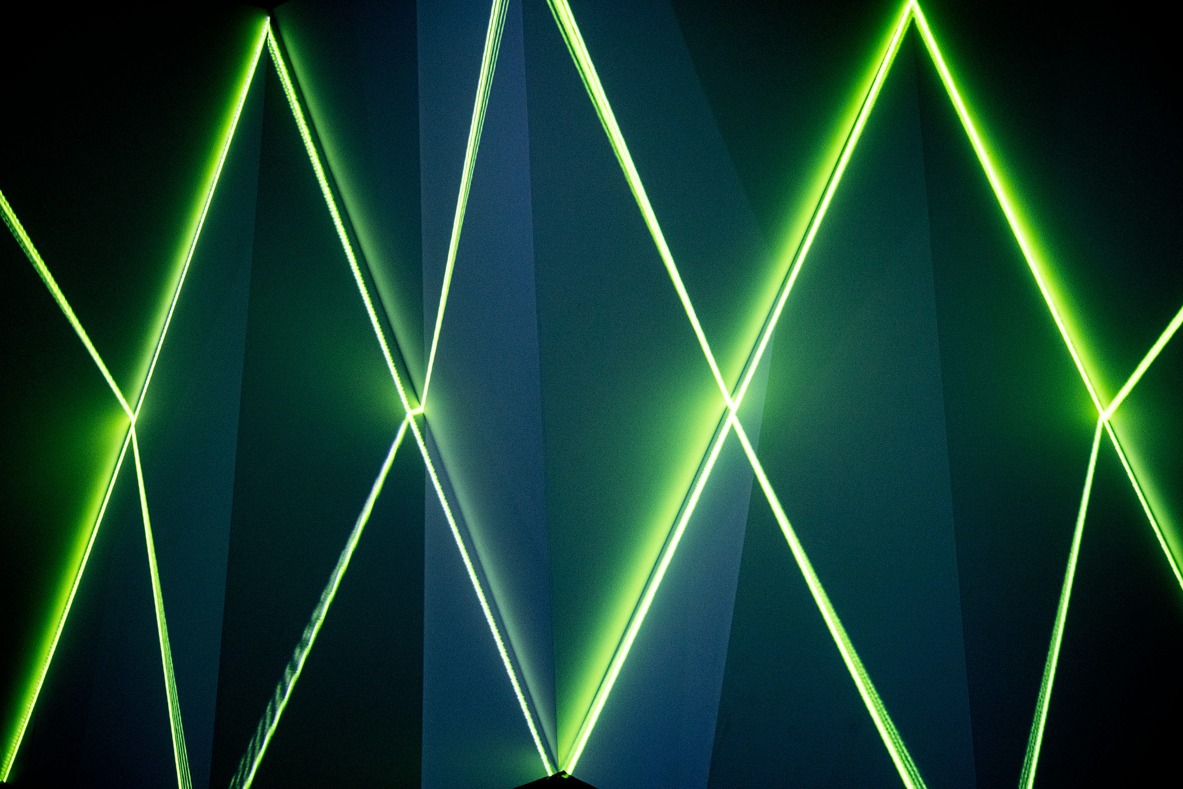 Gröna laserstrålar mot mörk bakgrund