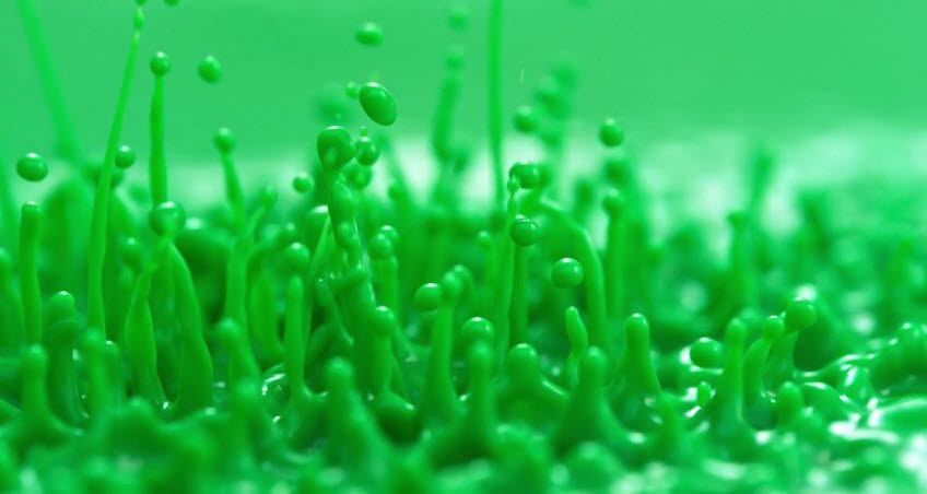 En grön vätska bildar droppar mot en grön bakgrund.