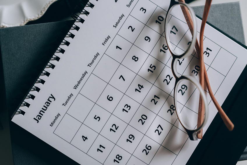 En kalender med ett par glasögon liggandes på ett bord