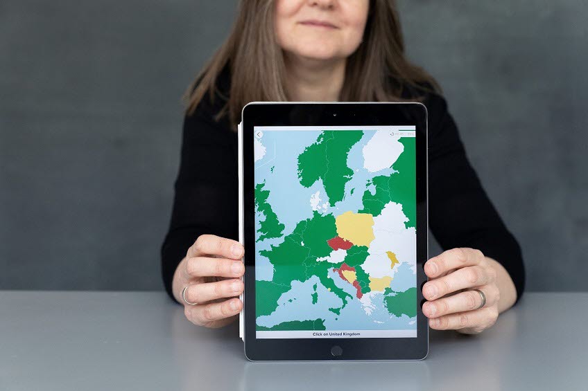 Kvinna som visar ett geografispel på en Ipad