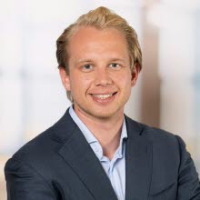 Porträttbild på blond man med blå kavaj