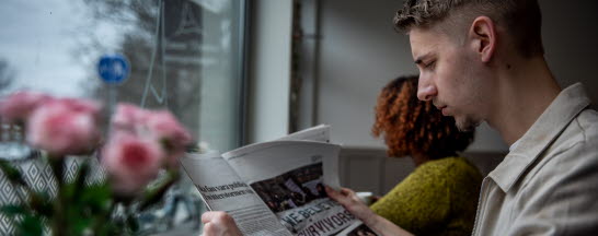 Man läser tidning på ett café.