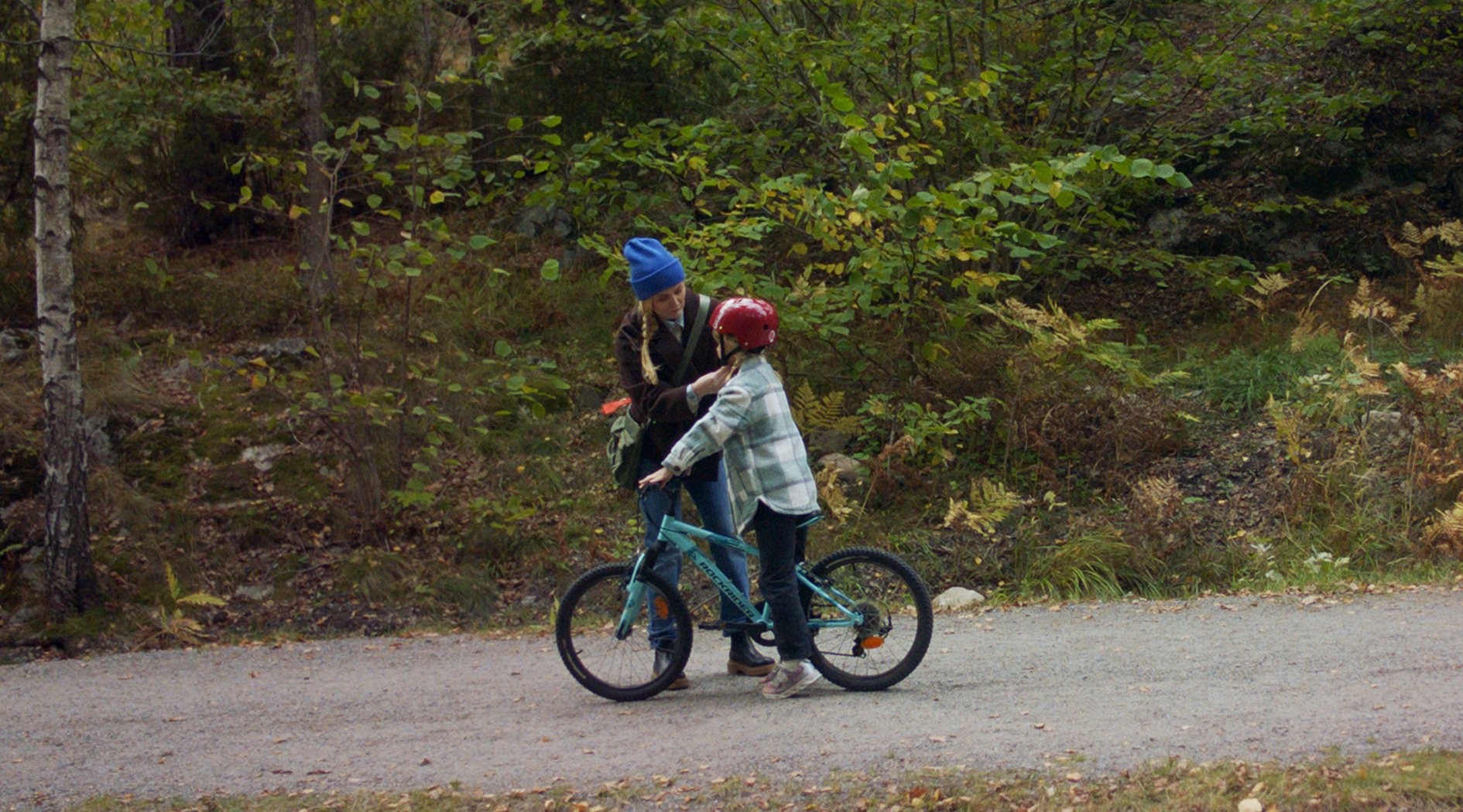 En mamma sätter cykelhjälm på sin dotter