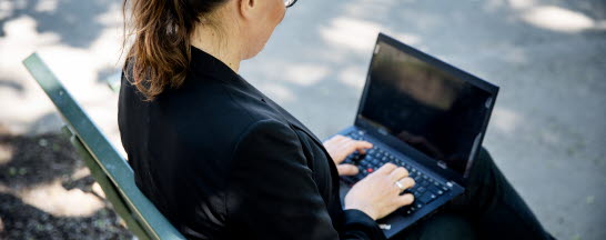 Kvinna med dator på en bänk