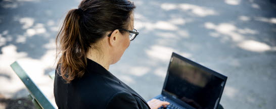 Woman with laptop sitting on a bench
