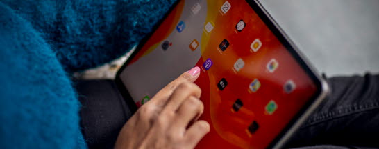 Någon trycker på appar på en IPad.